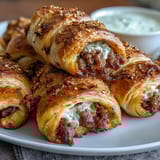 Golden mini pigs in a blanket with flaky crescent dough, served with tangy honey mustard dipping sauce for a perfect party appetizer.  