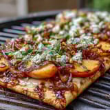 Sweet grilled peaches and creamy Brie cheese melt together on BBQ-sauced flatbread, topped with fresh basil.