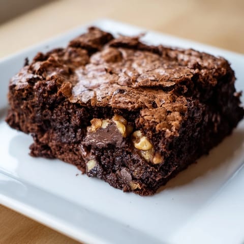Warm, fudgy brownies fresh from the oven, with a crackly top and rich chocolate aroma.