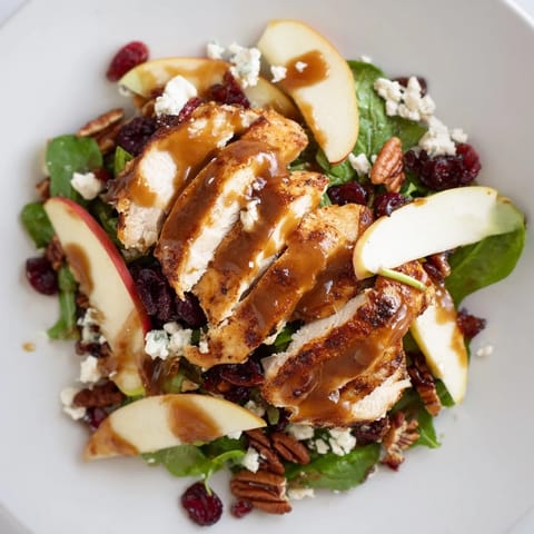 Freshly tossed Caramel Apple Chicken Salad with tender chicken slices, crisp Honeycrisp apple rounds, and candied pecans on vibrant mixed greens.