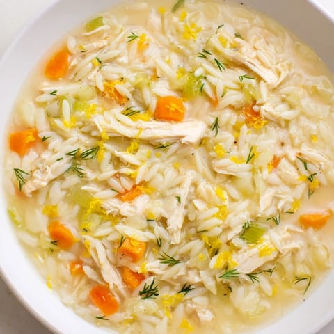 Comforting Mediterranean Chicken Lemon Orzo Soup simmering in a pot with orzo pasta and bright lemon zest.  