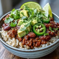 Hearty chili bowl base served over fluffy white rice, topped with shredded cheddar, sour cream, and fresh cilantro.