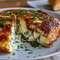 Spring brunch frittata with asparagus and goat cheese, golden and fluffy, served warm with fresh herbs.